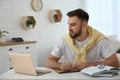 Young man taking notes during online webinar at table Royalty Free Stock Photo