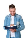 Young man taking notes and smiling, isolated over white background Royalty Free Stock Photo