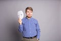 Young man taking off plain white mask revealing face, gray background Royalty Free Stock Photo