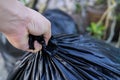 Young man taking out garbage in black plastic bag Royalty Free Stock Photo