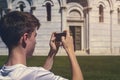 Young man taking a photo of the leaning tower of Pisa Royalty Free Stock Photo