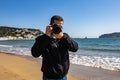 Young man taking a picture with a DSLR camera front shot at the beach Royalty Free Stock Photo