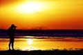 Young man taking a picture in front of the sea at dusk Royalty Free Stock Photo