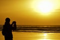 Young man taking a picture in front of the sea at dusk Royalty Free Stock Photo