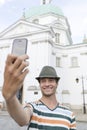 Young man taking self portrait outside St. Casimir Church, Warsaw, Poland