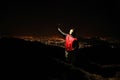 Young man taking selfie on top of the hill observing the night city view. Royalty Free Stock Photo