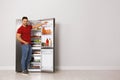 Young man taking yoghurt out of refrigerator indoors Royalty Free Stock Photo