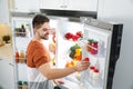 Young man taking yoghurt out of refrigerator Royalty Free Stock Photo