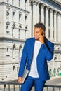 Young man talking on cell phone outside office building in New York City