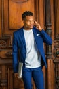 Young man talking on cell phone, standing by office door in New York City