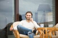Young man talking by cell sitting on house terrace chair Royalty Free Stock Photo