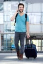 Young man talking on mobile phone with bag Royalty Free Stock Photo