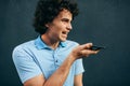 Young man talking on mobile phone with his girlfriend. Happy male with curly hair resting outside making a call on his smart phone Royalty Free Stock Photo