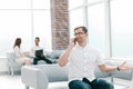 Young man talking on a mobile phone in the lobby of the business center Royalty Free Stock Photo