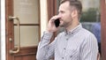 Young Man Talking on Phone while Sitting Outdoor Royalty Free Stock Photo