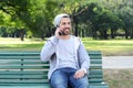 Young man talking on the phone sitting on park bench. Royalty Free Stock Photo