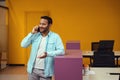 Young man talking on smartphone in the office Royalty Free Stock Photo
