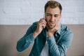 young man talking by smartphone and suffering from jaw pain