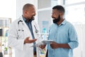 Young man talking to his doctor about his test results. Medical professional talking to a patient about their chart Royalty Free Stock Photo