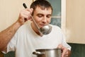 Young man tastes food Royalty Free Stock Photo