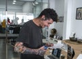 Young man tattooed cutting out the drawing of a tattoo.