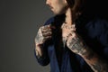 Young man with tattoos on body against black background, closeup Royalty Free Stock Photo