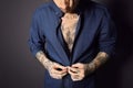 Young man with tattoos on body against black background, closeup Royalty Free Stock Photo