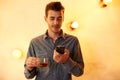 Young man with tea and cellphone Royalty Free Stock Photo