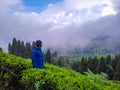 Young man at tea garden with mountain background and bright sky at morning Royalty Free Stock Photo