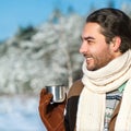 Young man with tea standing in snowy woods Royalty Free Stock Photo