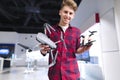 Young man is in the technology store with drones in his hands.man holds a quadcopter in his arms and smiles