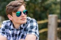 Young man teenager teen male adult outside wearing aviator sunglasses Royalty Free Stock Photo