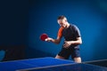Young man tennis-player in play on black background with lights Royalty Free Stock Photo