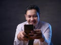 Young Man Texting Reading Chatting on His Phone, Smiling Happy Royalty Free Stock Photo