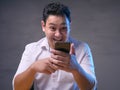 Young Man Texting Reading Chatting on His Phone, Smiling Happy Royalty Free Stock Photo