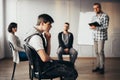 Young man thinking about an answear during group coaching session