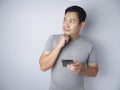 Young Man Thinking While Chatting on Smart Phone Royalty Free Stock Photo