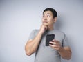 Young Man Thinking While Chatting on Smart Phone Royalty Free Stock Photo