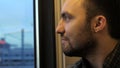 Young man thinking and looking at window in train. Royalty Free Stock Photo