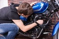 Young man tinkering with his motorbike