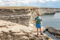 Happy young man on top of cliff enjoying view of sea. Mountains and sea Royalty Free Stock Photo