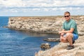 Happy young man on top of cliff enjoying view of sea. Mountains and sea Royalty Free Stock Photo