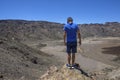 Young man on top of a mountain with amazing panoramic view. Success. Male hiker enjoying the beautiful view from the top. The