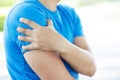 Young man touching painful twisted or broken shoulder. Athlete training accident. Sport Exercise is not warm, causing injury. and