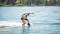Young man touching water surface during wakeboarding