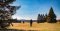 Young man tourist with backpack and white cap stand in czech landscape with trees and blue sky Royalty Free Stock Photo