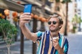 Young man tourist holdng ice cream make selfie by smartphone at street Royalty Free Stock Photo