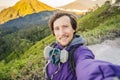 Young man tourist makes a selfie with the magnificent views on green mountains from a mountain road trecking to the Ijen Royalty Free Stock Photo