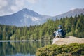 Tourist resting on rock above lake Royalty Free Stock Photo