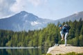 Tourist resting on rock above lake Royalty Free Stock Photo